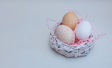 pastel Easter composition, eggs in a decorative nest on a pink background,