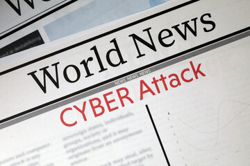 Top view of newspaper with headline CYBER ATTACK as background, closeup
