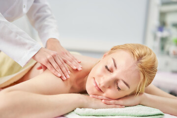 Acupuncture back massage for a woman in a medical center.