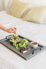 Wooden tray with tea and fruits Healthy breakfast in bed. Soft focus. Background.