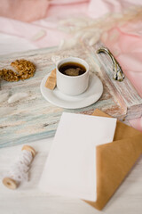 Wooden tray with tea and craft envelope with white card. Place for text. Soft focus. Blurred Background.