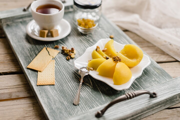 Wooden tray with tea and peaches and snacks. Healthy breakfast in the kitchen.
