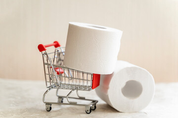 Rolls of toilet paper in Mini cart, trolley shopping. Concept of problem with consumer essential goods, hygiene, health