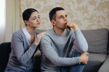 A woman comforts a sad man. Family support