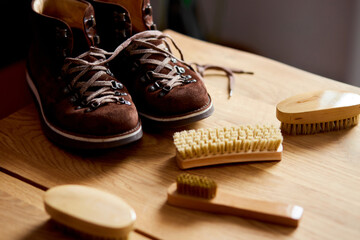 Fototapeta na wymiar Top view footwear with suede shoe boots care accessories, brush on wooden table.