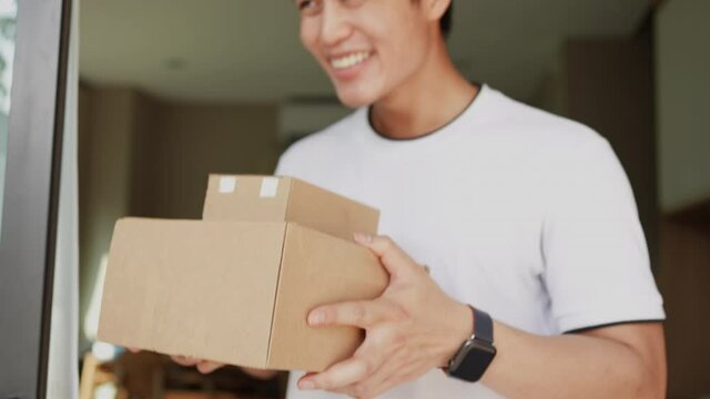 slow motion of asian man hand holding group of boxes while receiving form postman and say thank you for delivery business and transportation service concept