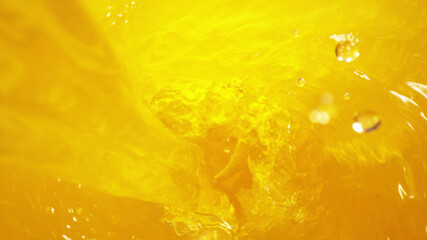 Detail of pouring orange juice in twister, freeze motion
