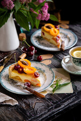 homemade two tasty slices of cottage cheese pie or cheesecake with apricots and cherries on top. selective focus
