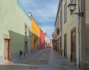 Pedestrian street of beautiful historic old town Vegueta. Houses with colorful facades and traditional wooden balcony. Las Palmas de Gran Canaria at sunny day. Canary Islands, Spain