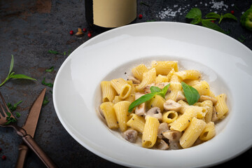 Mezze maniche or rigatoni pasta with cream sauce, parmesan and mushrooms. Italian Cuisine Recipe