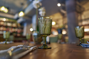 Vintage green glass goblet on a serving table in a restaurant.