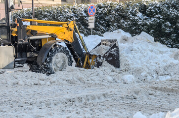Snow removal tractor clears the road from snow