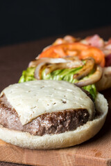 open burger with bacon, cheese, letucce, tomato, onions, and meat 