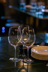 Glasses and cutlery on the table in the bar on the dark background