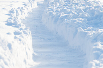 Fototapeta na wymiar winter emergency: deep trench-trail in the snow, dug for the passage of people after heavy snowfall