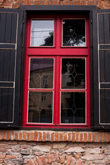 Vintage window with red frame, brick wall. Window. Uzhhgorod, Ukraine. 