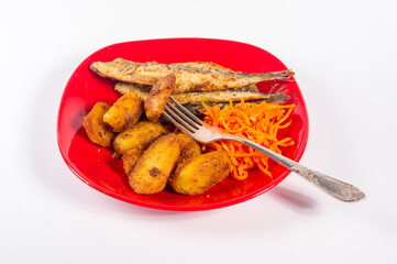 Homemade dish - fried potato wedges with small fish and pickled carrots on a red plate, simple rustic food, close-up.