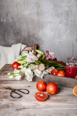 fresh blood orange juice in glasses and in bottle with fresh oranges in wooden tray on wooden table, copy space