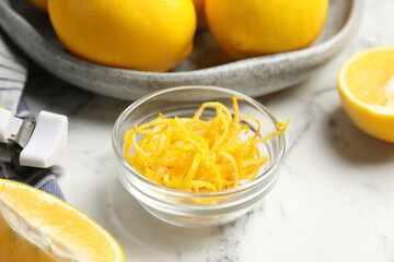 Lemon zest and fresh fruits on white marble table