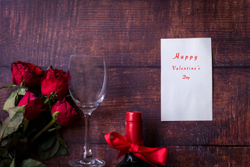 Valentine Day.  Red wine and red rose on old wood background.  Holiday and Valentine Concept.