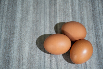 Fresh farm eggs on a rustic wooden background.