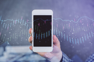 Double exposure of man's hands holding and using a digital device and forex graph drawing. Financial market concept.