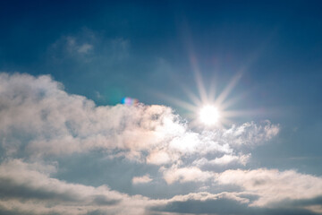 Sunset blue sky, bright sun shines through clouds.