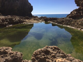 Reflejo de agua de mar entre las rocas en una playa del Algarve en Portugal