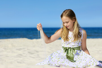 Beautiful girl on a sandy beach, blue sky in background