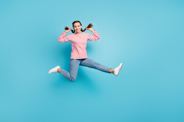 Full length photo of young cheerful girl happy positive smile have fun jump up isolated over blue color background