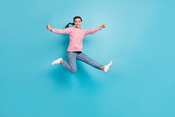 Fototapeta na wymiar Full body photo of young excited girl happy smile jump up show thumb-up like advice cool isolated over blue color background