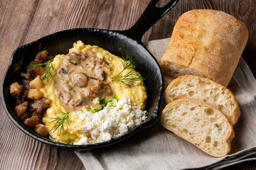 Banosh - a ukrainian dish made of cornmeal. Served in black pan with cracklings, mushrooms and...