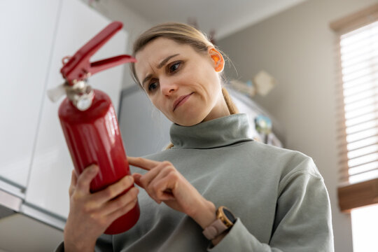 woman check the fire extinguisher expiration date at home