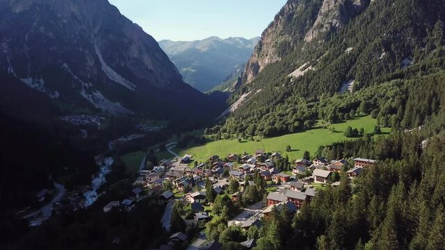 A small village in the middle of a valley in the French Alps, in the middle of the mountains with trees and mortifying hills