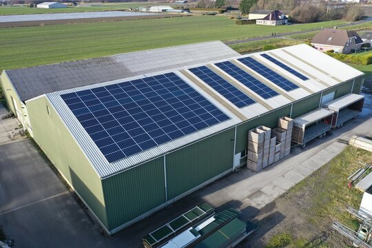 Flower bulb company with solar panels in a row on a roof. Photo taken with a drone