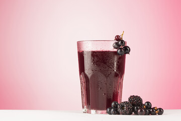 Drink from black currant on pink background