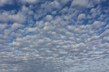 Typical stratocumulus clouds against a blue sky. Heavenly background.