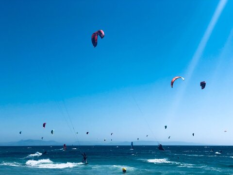 Cielo lleno de cometas de colores de kitesurf en Tarifa, C&aacute;diz