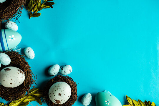 Painted Easter eggs and bird's nests decorations on a blue background