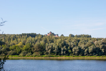 Fototapeta na wymiar castle in the forest on the bank of the Oka River. Green forest and river