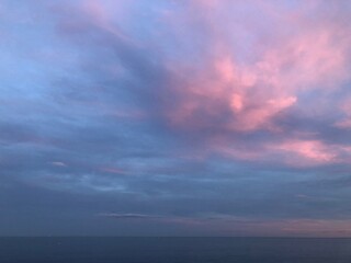 Atardecer rosado en la orilla de una playa de con mar