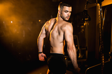 Young man athlete posing in the gym, stimulates to go in for sports