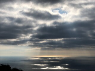 Rayos de sol penetrando las nubes blancas y proyectándose en el mar, divinidad, luz divina, Dios