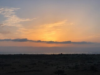 Atardecer con el cielo anaranjado y rosado en la playa cerca del mar de Fuerteventura