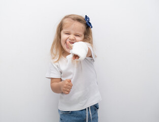 Little cute girl with hand in plaster showing the class on white background