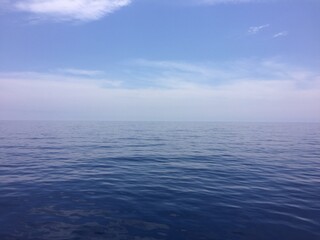 Fototapeta na wymiar Fonde de mar azul y cielo azul con nubes blancas, mar mediterráneo