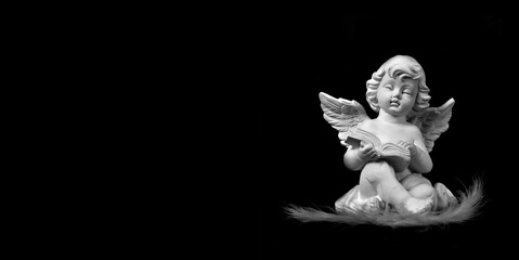 Sympathy card. Angel reading a book isolated on black background, copy space.