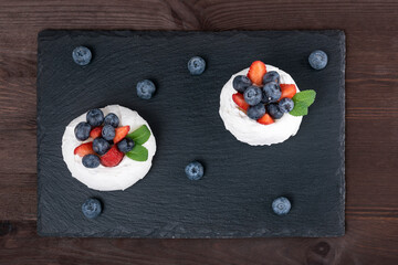 Cake Anna Pavlova. Airy meringue garnished with fresh strawberries and blueberries.