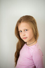 Emotional girl with blonde hair on a white background
Cute 8-10 year old girl in pink T-shirt