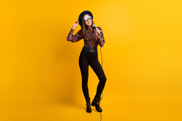Fototapeta na wymiar Full length body size photo of pop star singing performing song on stage in microphone isolated vibrant yellow color background